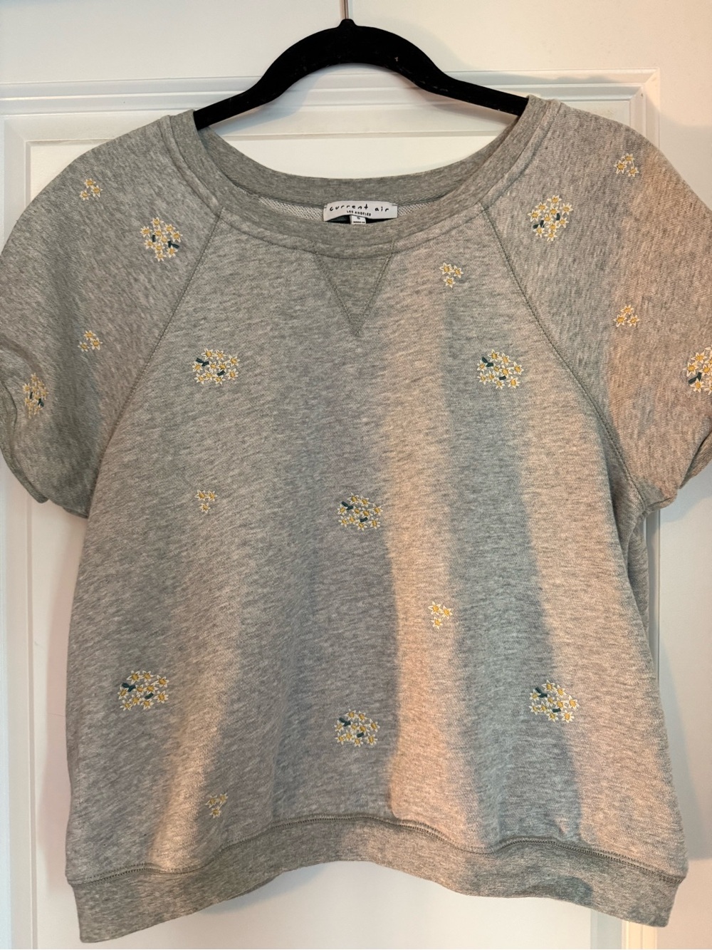 Grey short sleeve top with embroidered flowers.